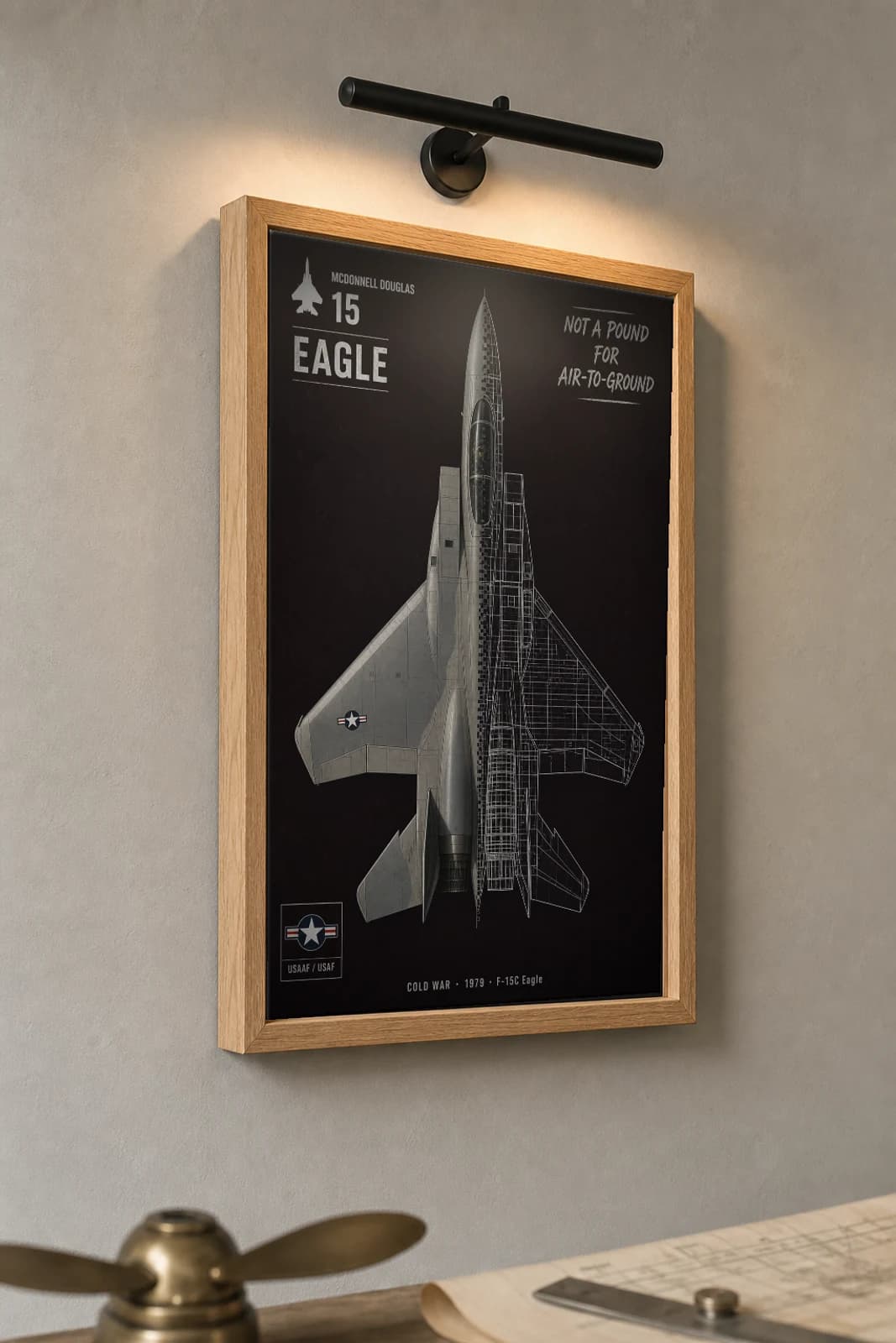 F-15 Eagle Cutaway Poster — F-15C Cold War Split-View Blueprint Print — the framed print shown at a three-quarter angle on a styled gallery wall in a natural-oak frame