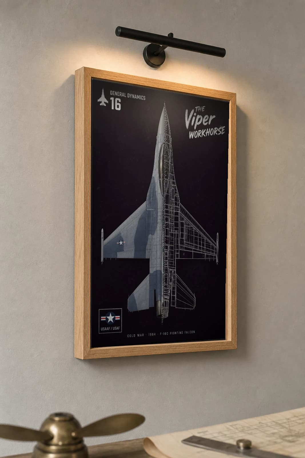 F-16 Fighting Falcon Cutaway Poster — F-16C Cold War Split-View Blueprint Print — the framed print shown at a three-quarter angle on a styled gallery wall in a natural-oak frame