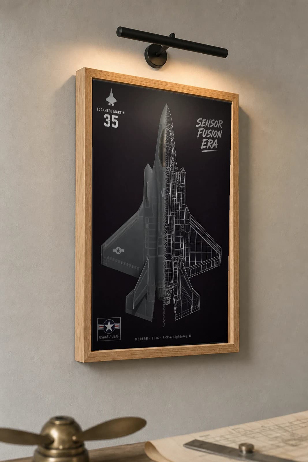 F-35 Lightning II Cutaway Poster — F-35A Modern Split-View Blueprint Print — the framed print shown at a three-quarter angle on a styled gallery wall in a natural-oak frame