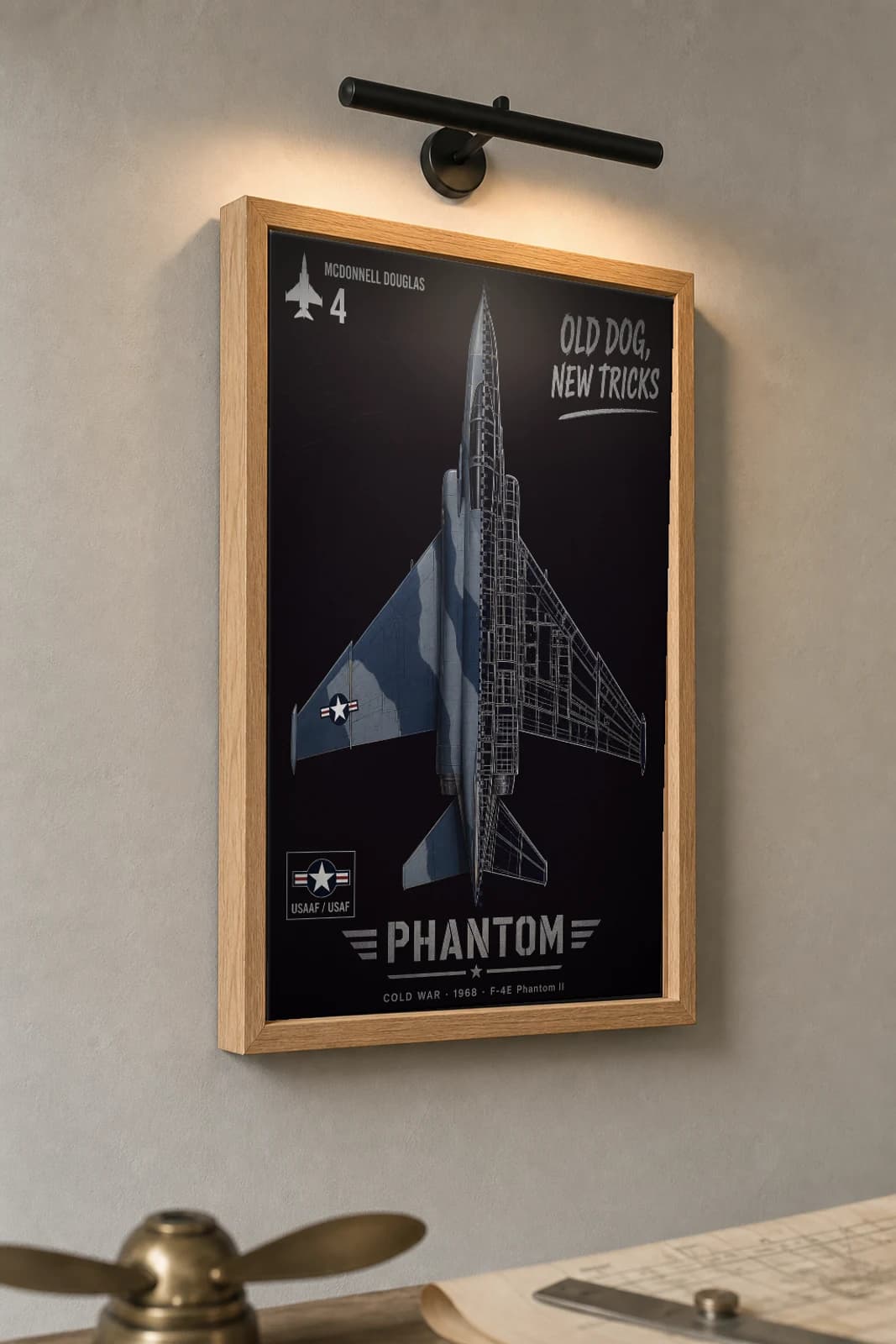 F-4E Phantom II Cutaway Poster — F-4E Phantom II Cold War Split-View Blueprint Print — the framed print shown at a three-quarter angle on a styled gallery wall in a natural-oak frame
