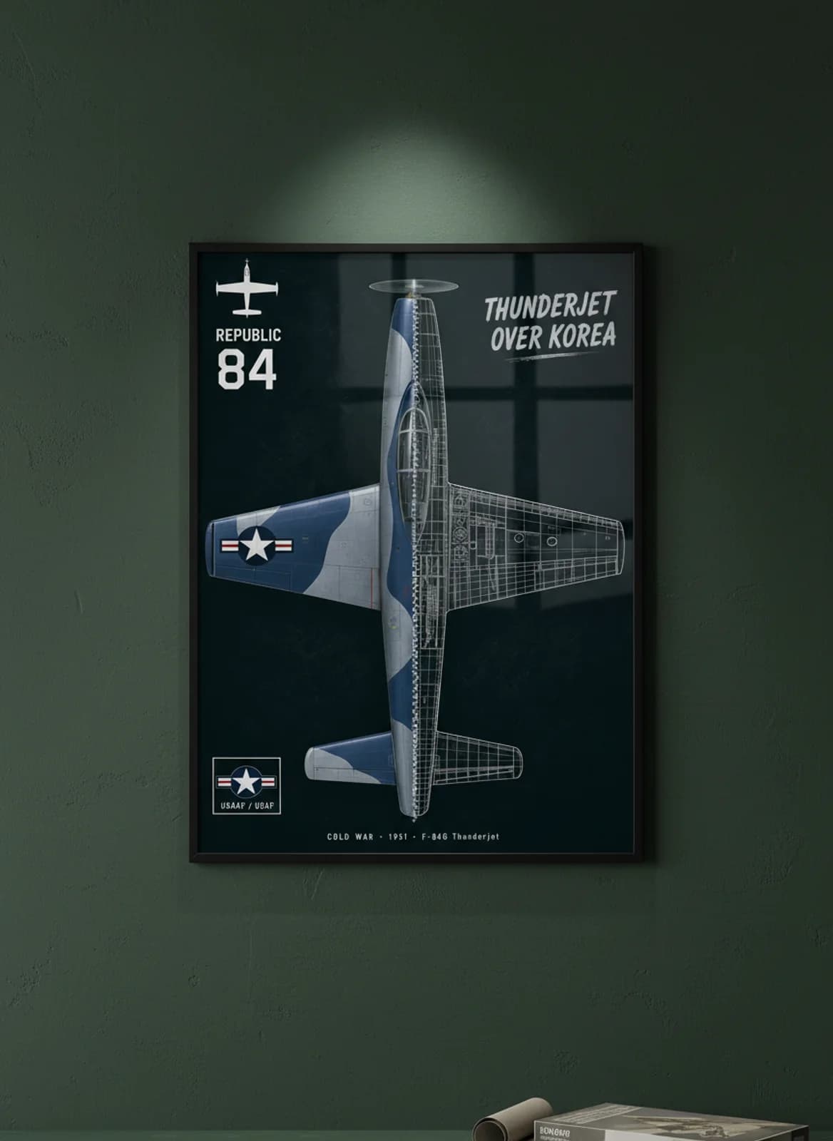 F-84G Thunderjet cutaway poster in black A2 frame on blue-grey-camouflage deep forest wall — Aircraft Cutaways enthusiast study mockup