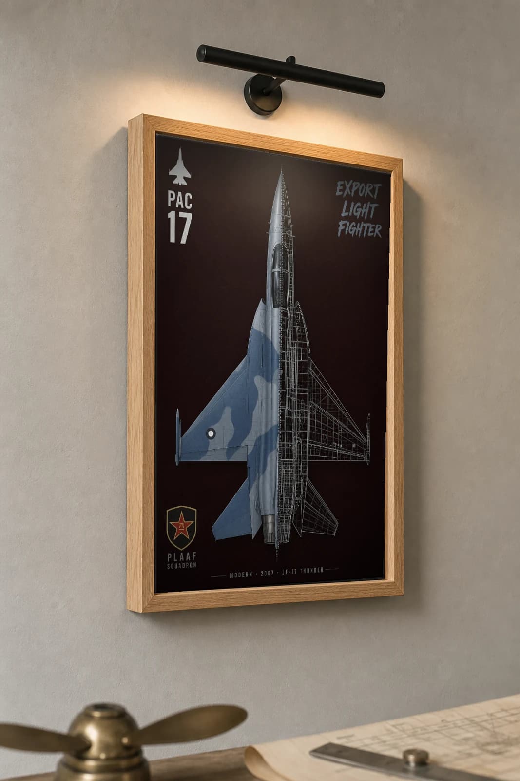 JF-17 Thunder Cutaway Poster — Block II Modern Split-View Blueprint Print — the framed print shown at a three-quarter angle on a styled gallery wall in a natural-oak frame