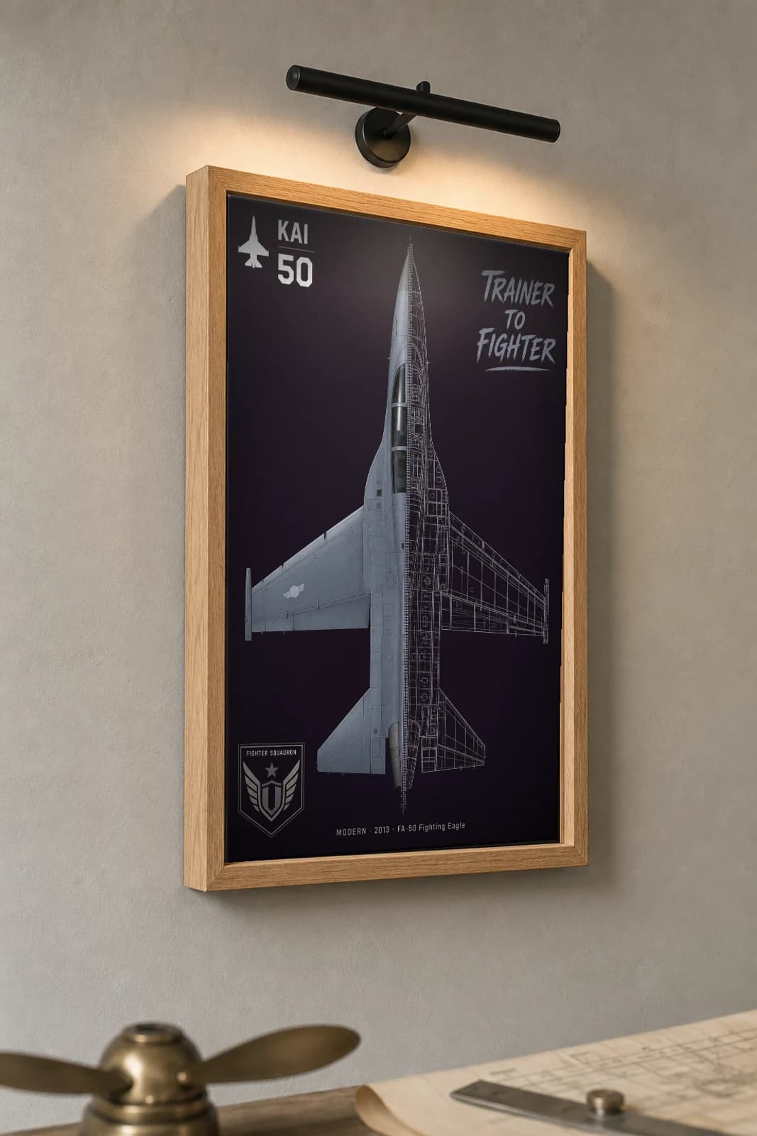 KAI FA-50 Cutaway Poster — FA-50 Fighting Eagle Modern Split-View Blueprint Print — the framed print shown at a three-quarter angle on a styled gallery wall in a natural-oak frame