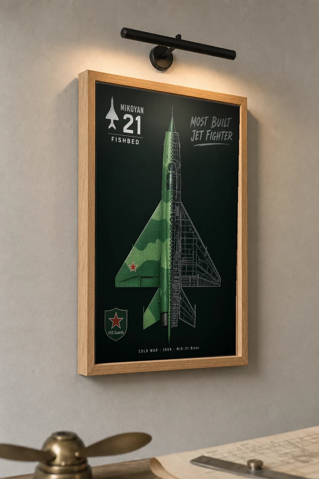 MiG-21 Cutaway Poster — MiG-21 Bison Cold War Split-View Blueprint Print — the framed print shown at a three-quarter angle on a styled gallery wall in a natural-oak frame