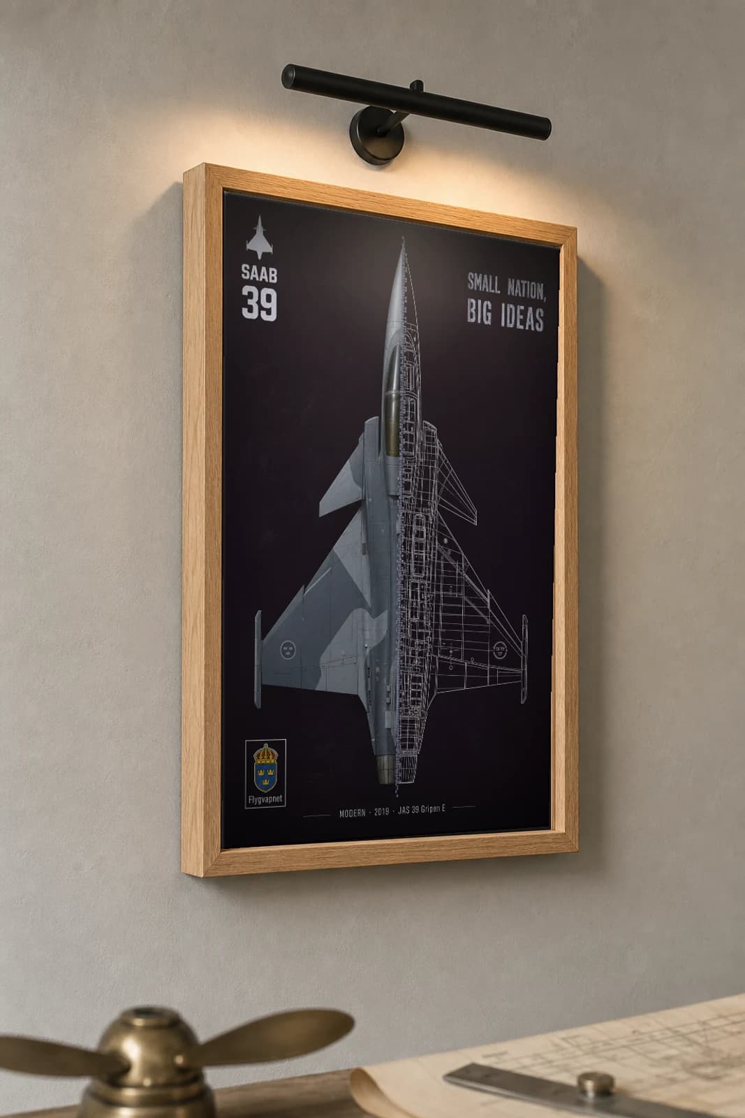 JAS 39 Gripen E Cutaway Poster — Gripen E Modern Split-View Blueprint Print — the framed print shown at a three-quarter angle on a styled gallery wall in a natural-oak frame