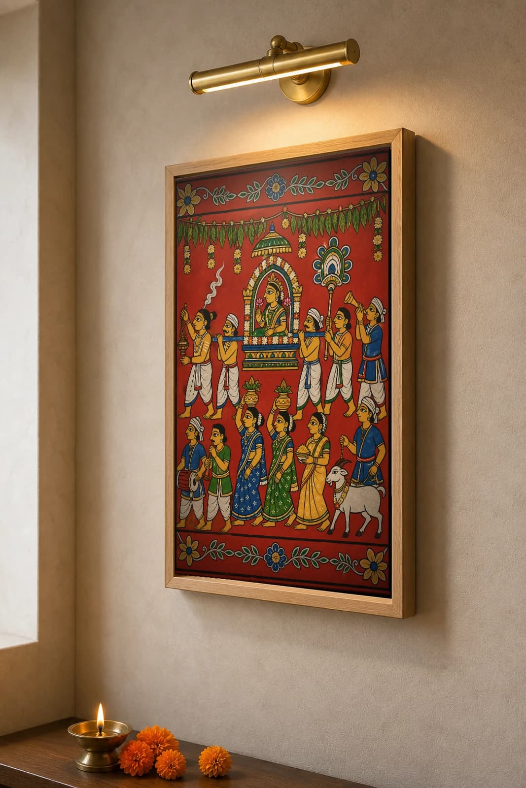 Gramadevata Ooregimpu Cheriyal Fusion Print — A Deccani Village Goddess Borne Through Her Streets, Nakashi Folk Grammar on a Vermilion Ground — the framed print shown at a three-quarter angle on a styled gallery wall in a natural-oak frame