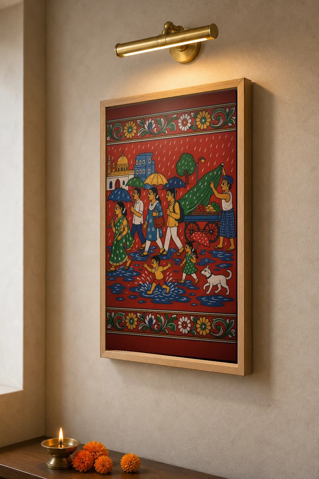 Monsoon Umbrella Street Cheriyal Print — a Telangana town in the rain, umbrellas and a fruit cart · collector edition on vermilion ground · Nakashi scroll grammar from Telangana — the framed print shown at a three-quarter angle on a styled gallery wall in a natural-oak frame