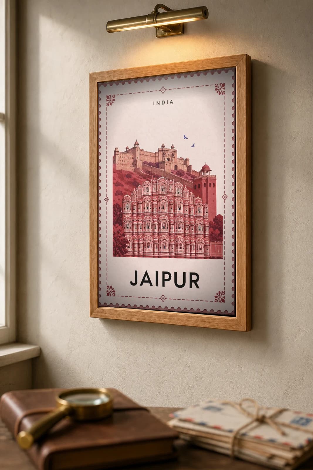 Jaipur City Stamp Poster — India travel wall art · illustrated stamp print · framed A2 — the framed print shown at a three-quarter angle on a styled gallery wall in a natural-oak frame