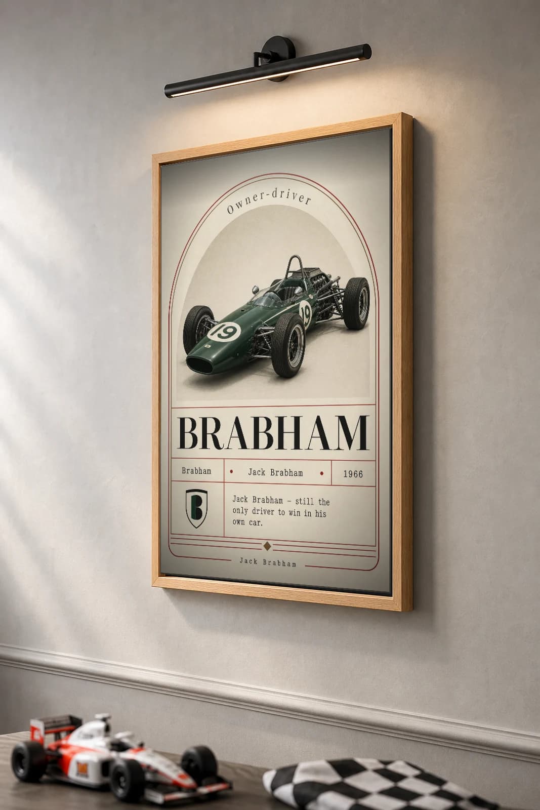 Jack Brabham — Jack Brabham — classic Brabham 66 heritage plate Poster — 66 F1 Grid Editorial Wall Art · framed A2 — the framed print shown at a three-quarter angle on a styled gallery wall in a natural-oak frame