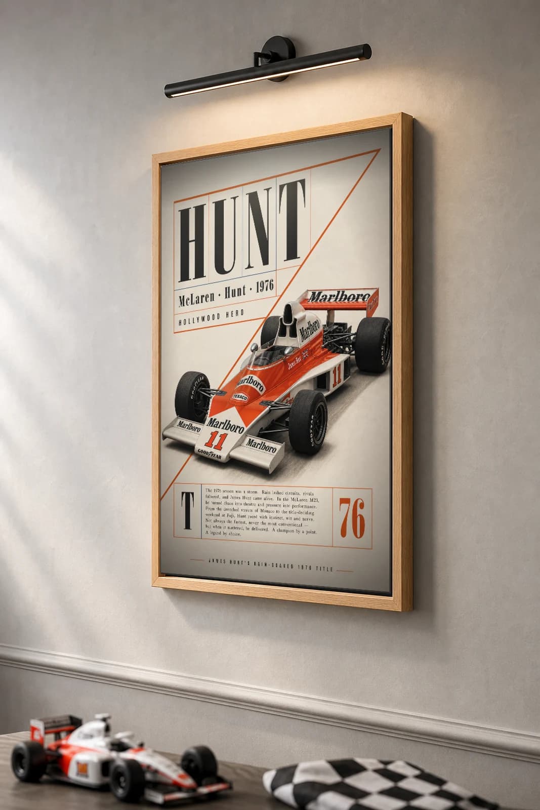 James Hunt — James Hunt — classic McLaren 76 heritage plate Poster — 76 F1 Grid Editorial Wall Art · framed A2 — the framed print shown at a three-quarter angle on a styled gallery wall in a natural-oak frame