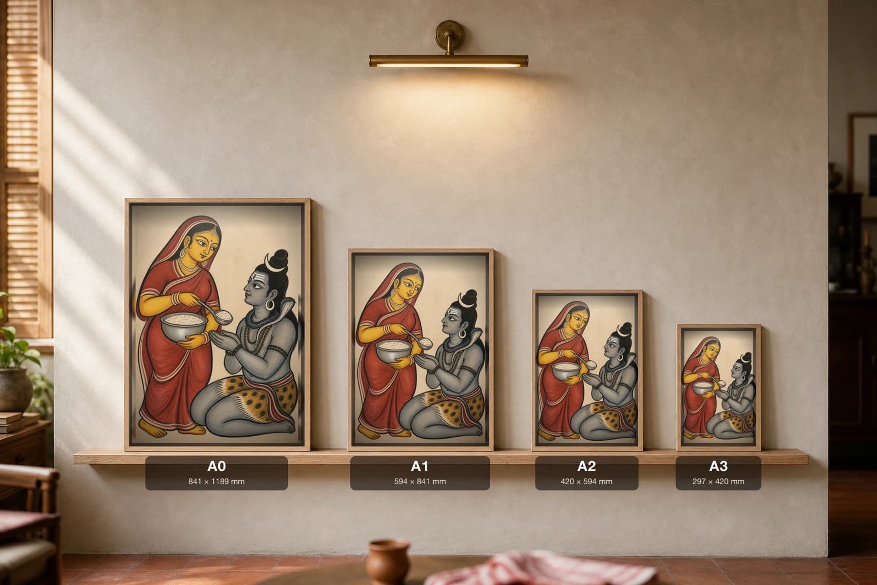 Annapurna Kalighat Print — the goddess of food ladles rice to kneeling Shiva, devotional Bengal patua brush, hand-numbered collector edition — print size guide showing the artwork at A0, A1, A2 and A3 in natural-oak frames at true relative scale