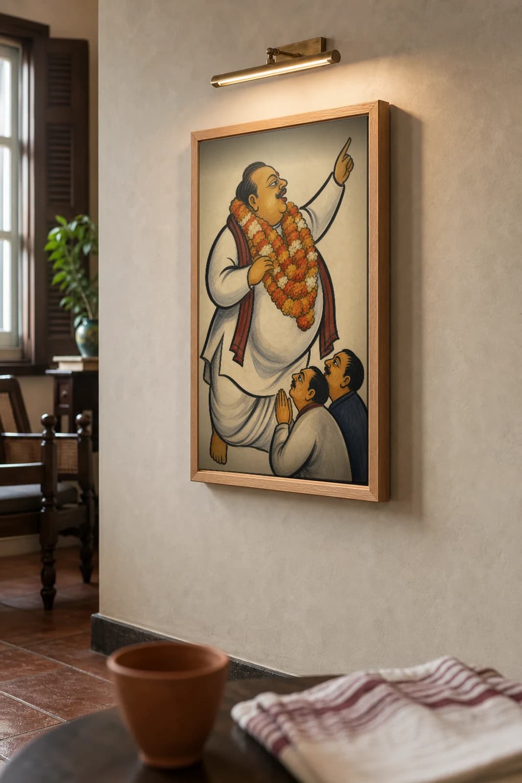 The Neta — Kalighat-style art print of a garlanded politician mid-speech with two sycophants, Bengal patua brush · collector edition · framed A2 — the framed print shown at a three-quarter angle on a styled gallery wall in a natural-oak frame