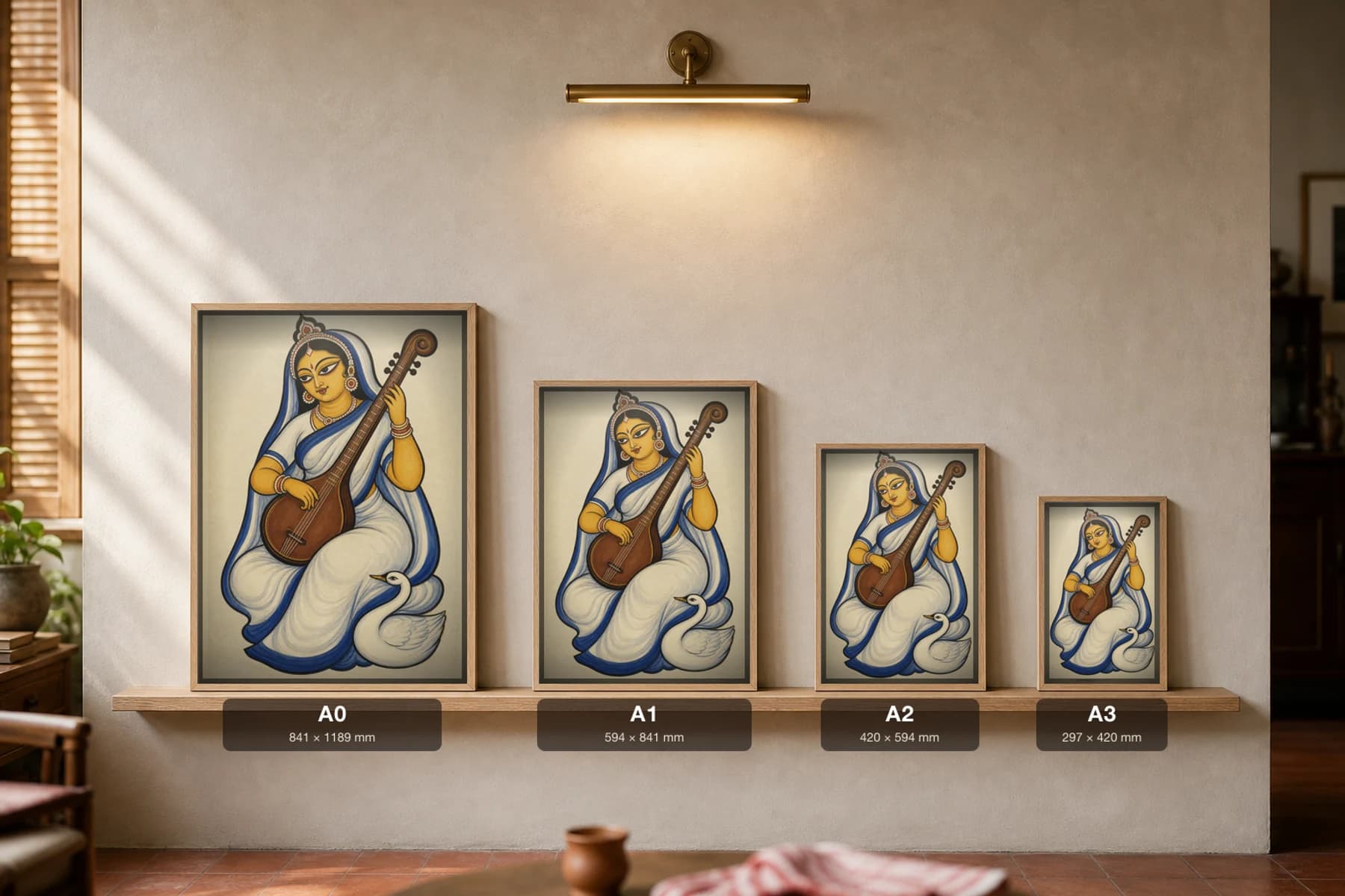 Saraswati — Kalighat-style devotional art print of the goddess of learning with her veena and swan, Bengal patua brush · collector edition · framed A2 — print size guide showing the artwork at A0, A1, A2 and A3 in natural-oak frames at true relative scale