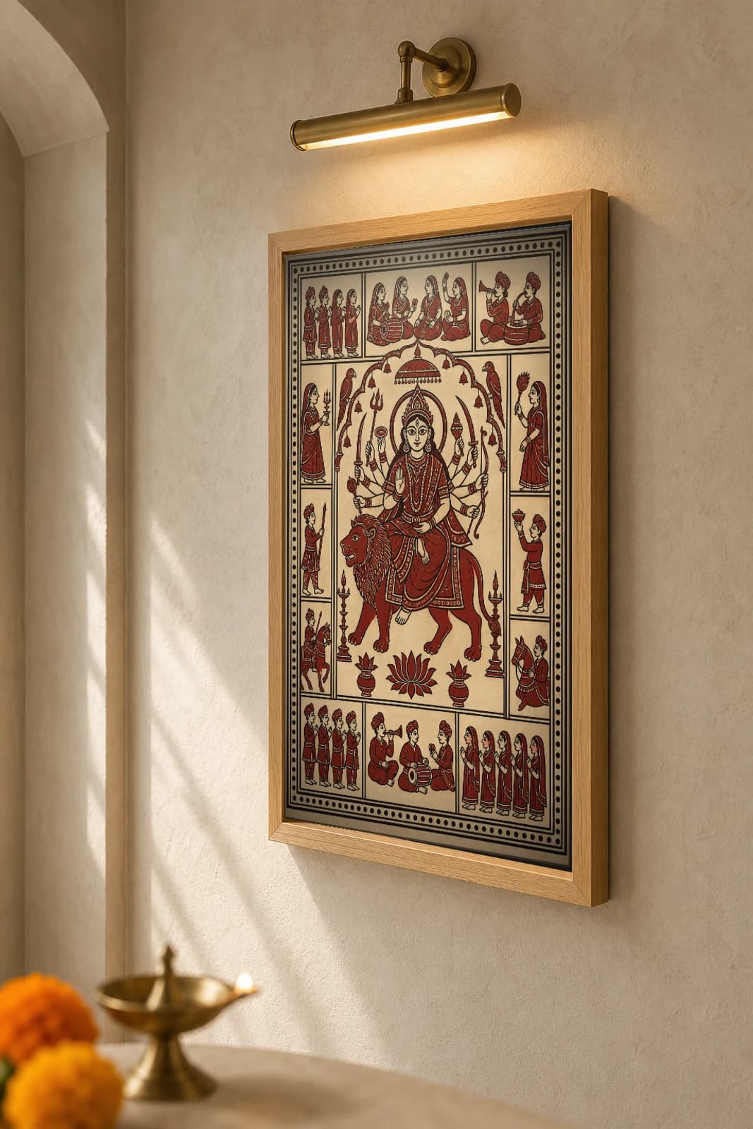 Amba Mata on the Lion — Mata ni Pachedi shrine-cloth art print · eight-armed mother enthroned on the Arasur lion · madder-red, iron-black and warm-ecru cotton · collector edition — the framed print shown at a three-quarter angle on a styled gallery wall in a natural-oak frame