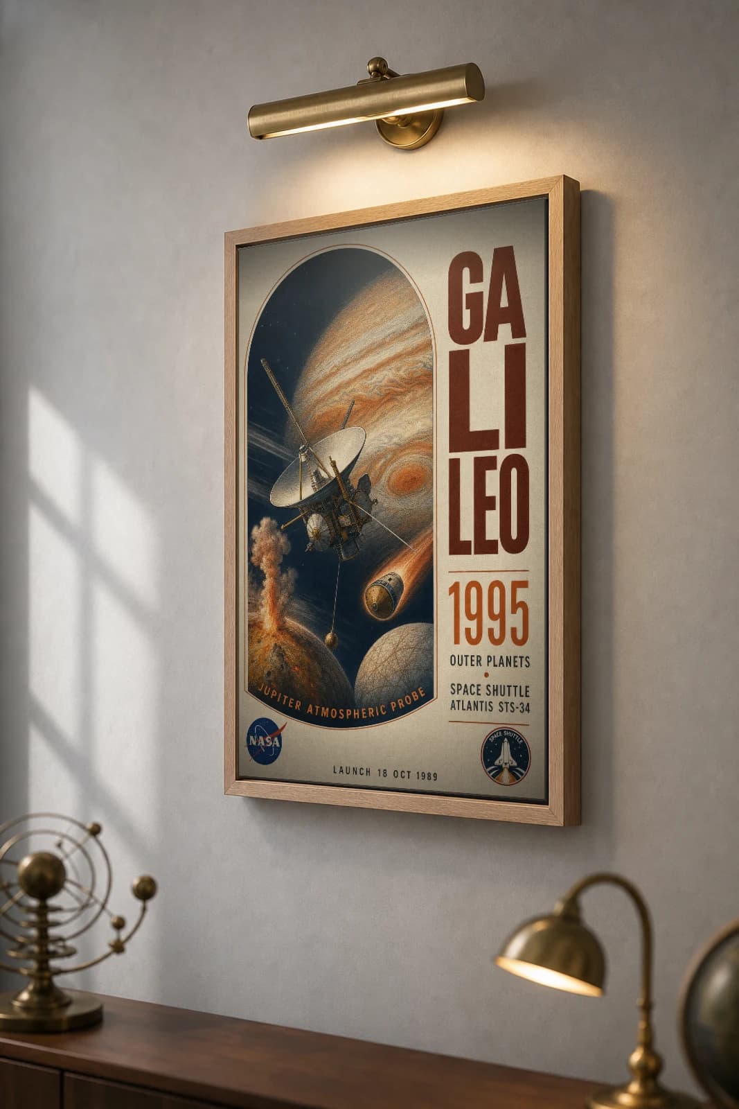 Galileo Poster — 1995 Jupiter Orbiter NASA Heritage Collector Print — the framed print shown at a three-quarter angle on a styled gallery wall in a natural-oak frame