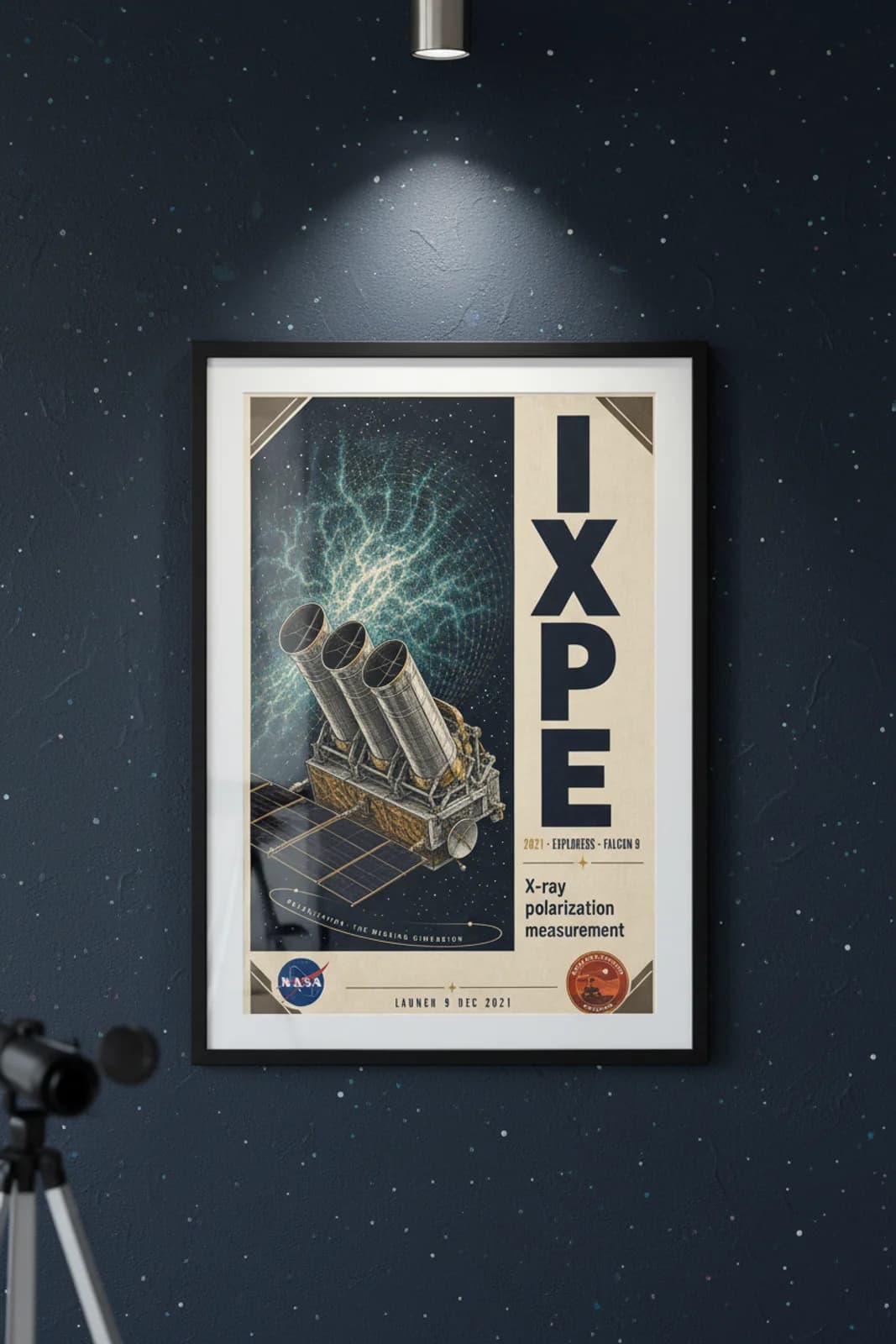 IXPE poster in black A2 frame on deep-navy-space deep space navy wall — NASA Heritage collector study mockup