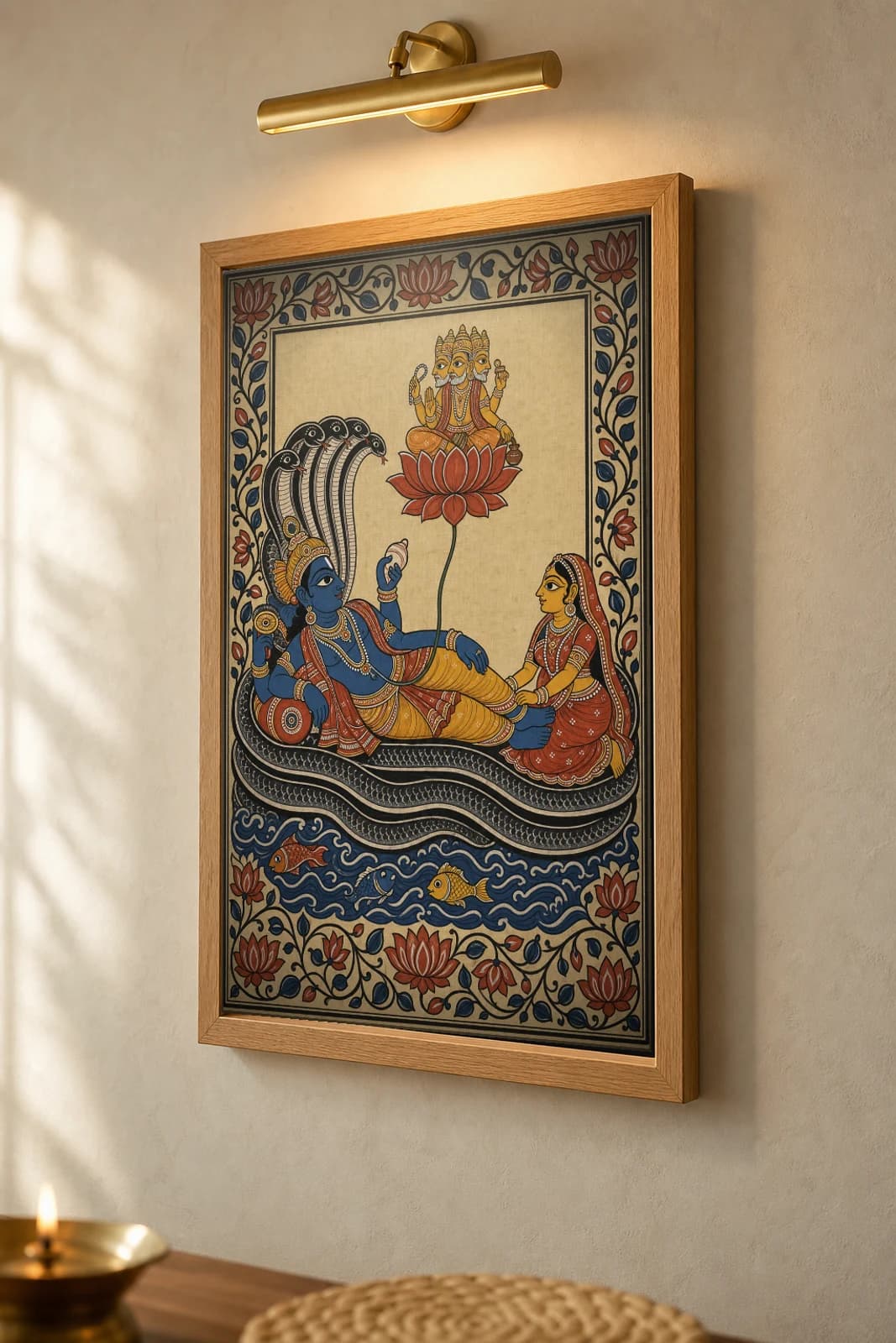 Ananta Shayana Pattachitra Print — Vishnu reclining on the cosmic serpent with Lakshmi and lotus-born Brahma · collector edition A2 · classical Odisha cloth-painting grammar — the framed print shown at a three-quarter angle on a styled gallery wall in a natural-oak frame