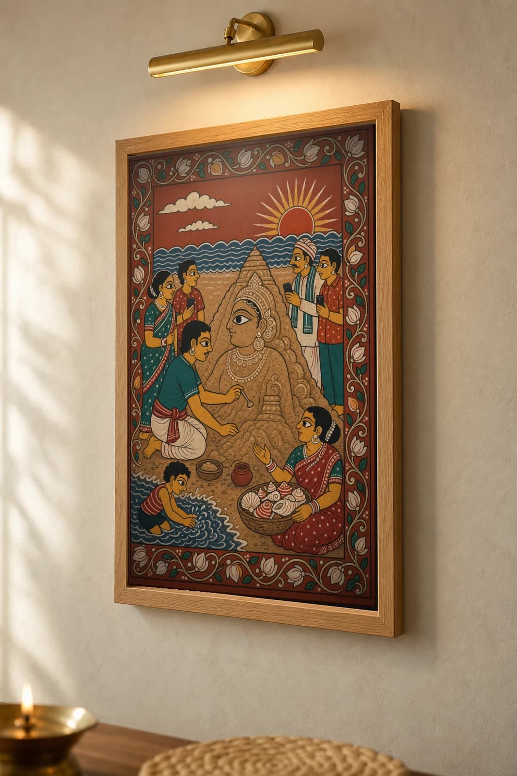 Sand-Art Morning Pattachitra Print — a sand sculptor on Puri beach at sunrise in Odisha cloth-painting grammar · collector A2 · contemporary fusion — the framed print shown at a three-quarter angle on a styled gallery wall in a natural-oak frame