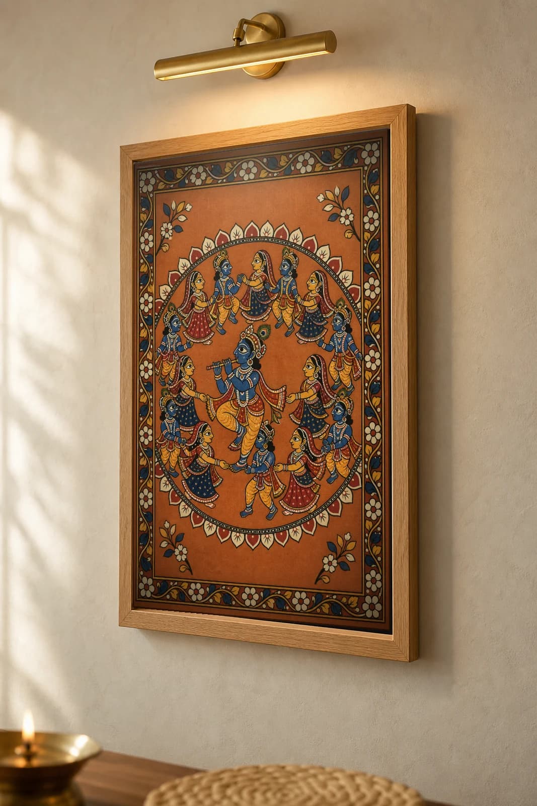 Rasa Mandala Pattachitra Print — Krishna and the gopis in the circular night dance in Odisha cloth-painting grammar · collector A2 · Krishna leela — the framed print shown at a three-quarter angle on a styled gallery wall in a natural-oak frame
