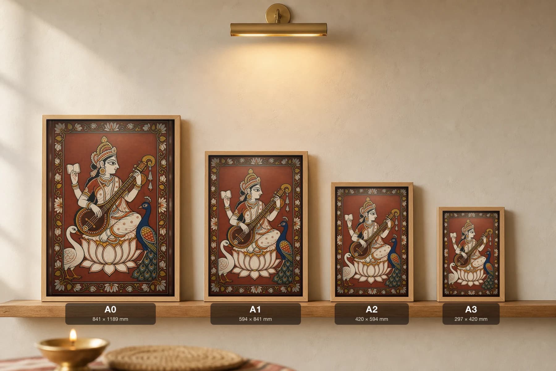 Saraswati Pattachitra Print — the goddess of learning with her veena in Odisha cloth-painting grammar · collector A2 · Devi / Shakti — print size guide showing the artwork at A0, A1, A2 and A3 in natural-oak frames at true relative scale