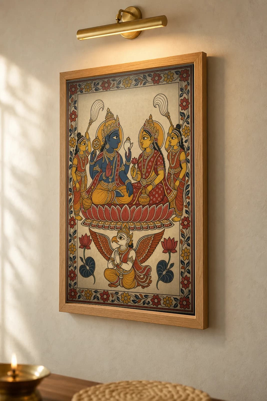 Vishnu Lakshmi Pattachitra Print — the divine couple enthroned on a lotus with Garuda in Odisha cloth-painting grammar · collector A2 · Vishnu — the framed print shown at a three-quarter angle on a styled gallery wall in a natural-oak frame
