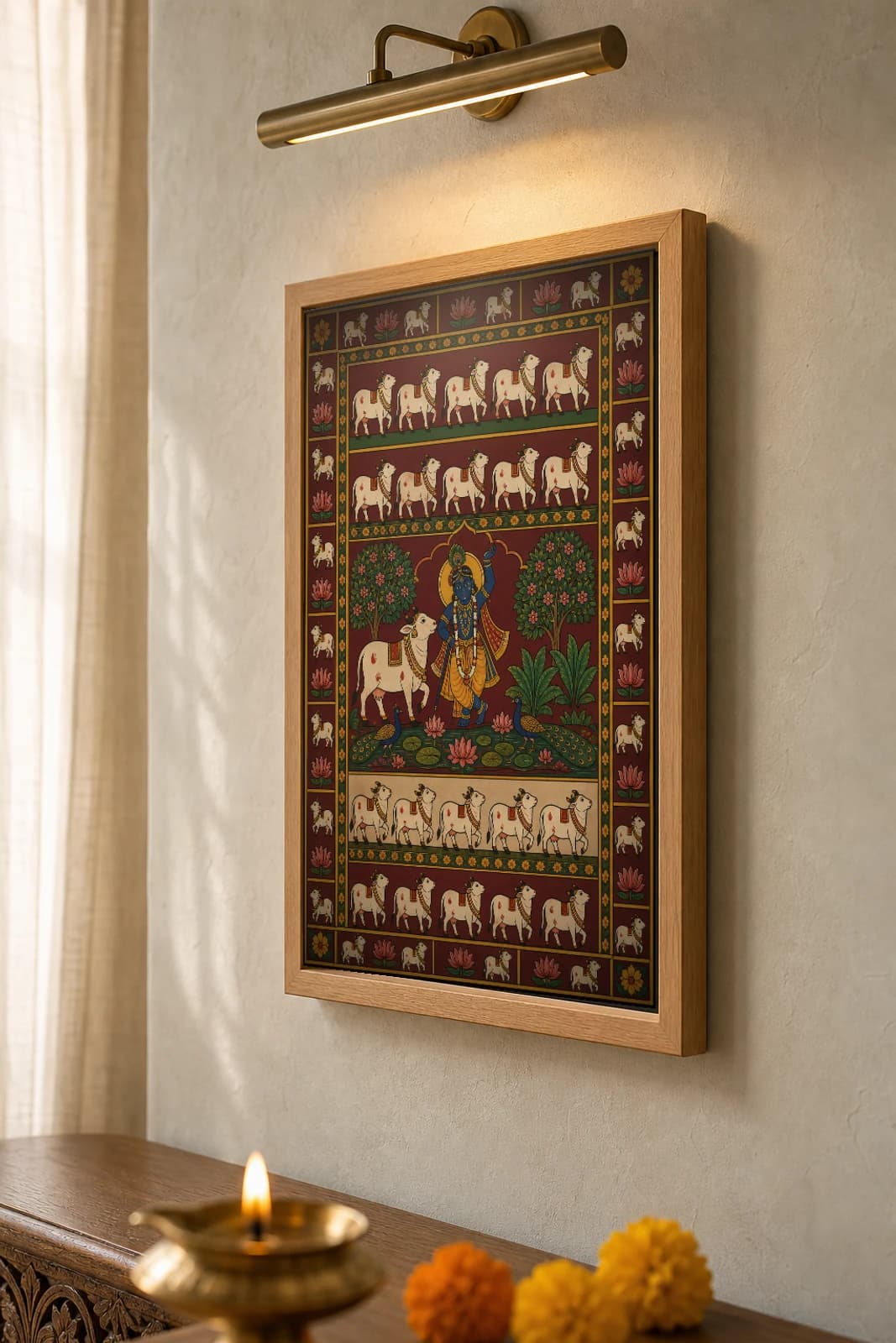 Dhenu Pankti Pichwai-Style Print — Shrinathji at centre flanked by a white cow and trees, with rows of marching cows above and below, on deep maroon cloth — the framed print shown at a three-quarter angle on a styled gallery wall in a natural-oak frame