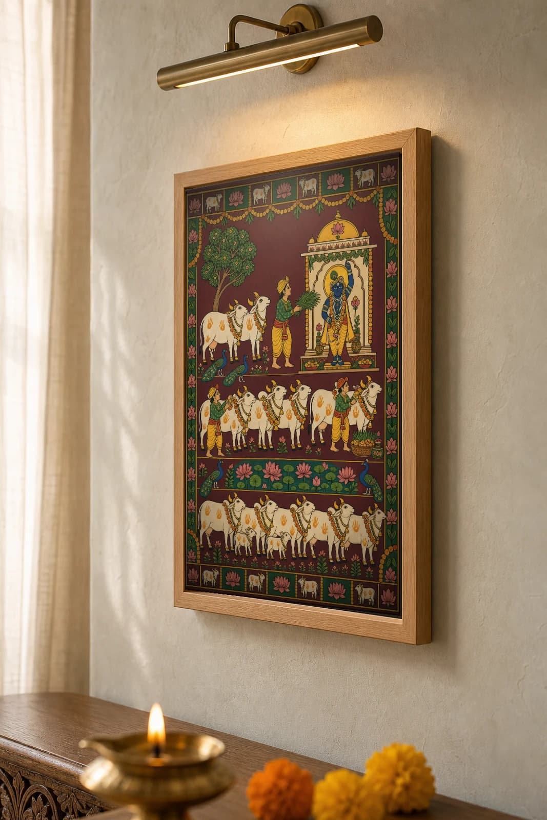 Gopashtami Seva Pichwai-Style Print — cowherds garlanding and adorning cows before a shrined Shrinathji, with calves and a lotus pond, on deep maroon cloth — the framed print shown at a three-quarter angle on a styled gallery wall in a natural-oak frame