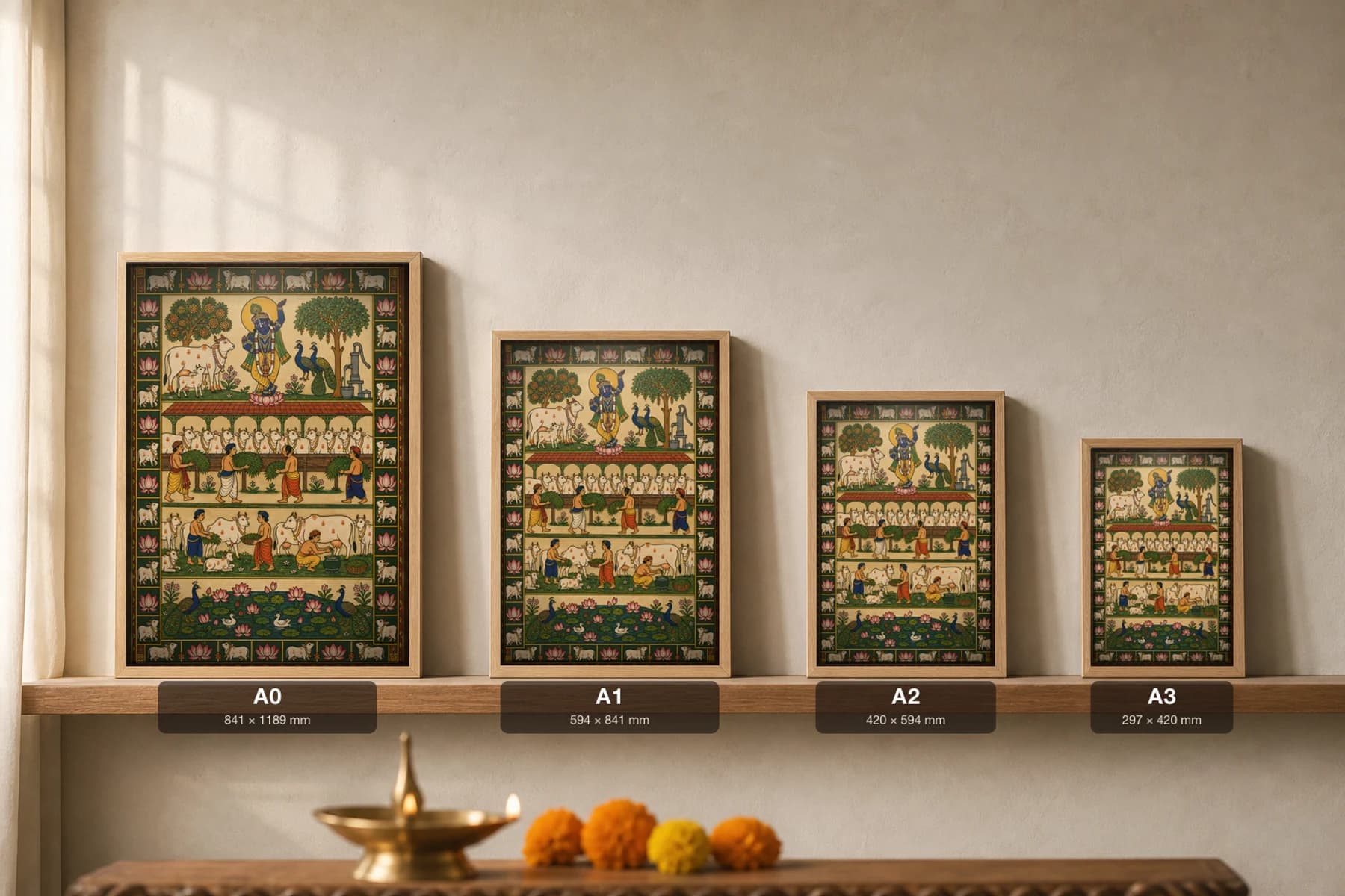 Goshala Seva Pichwai-Style Print — volunteers feeding fodder to rows of cows in a covered cow-shed below a flute Krishna, with milking, a hand-pump and a lotus pond, on warm cream cloth — print size guide showing the artwork at A0, A1, A2 and A3 in natural-oak frames at true relative scale