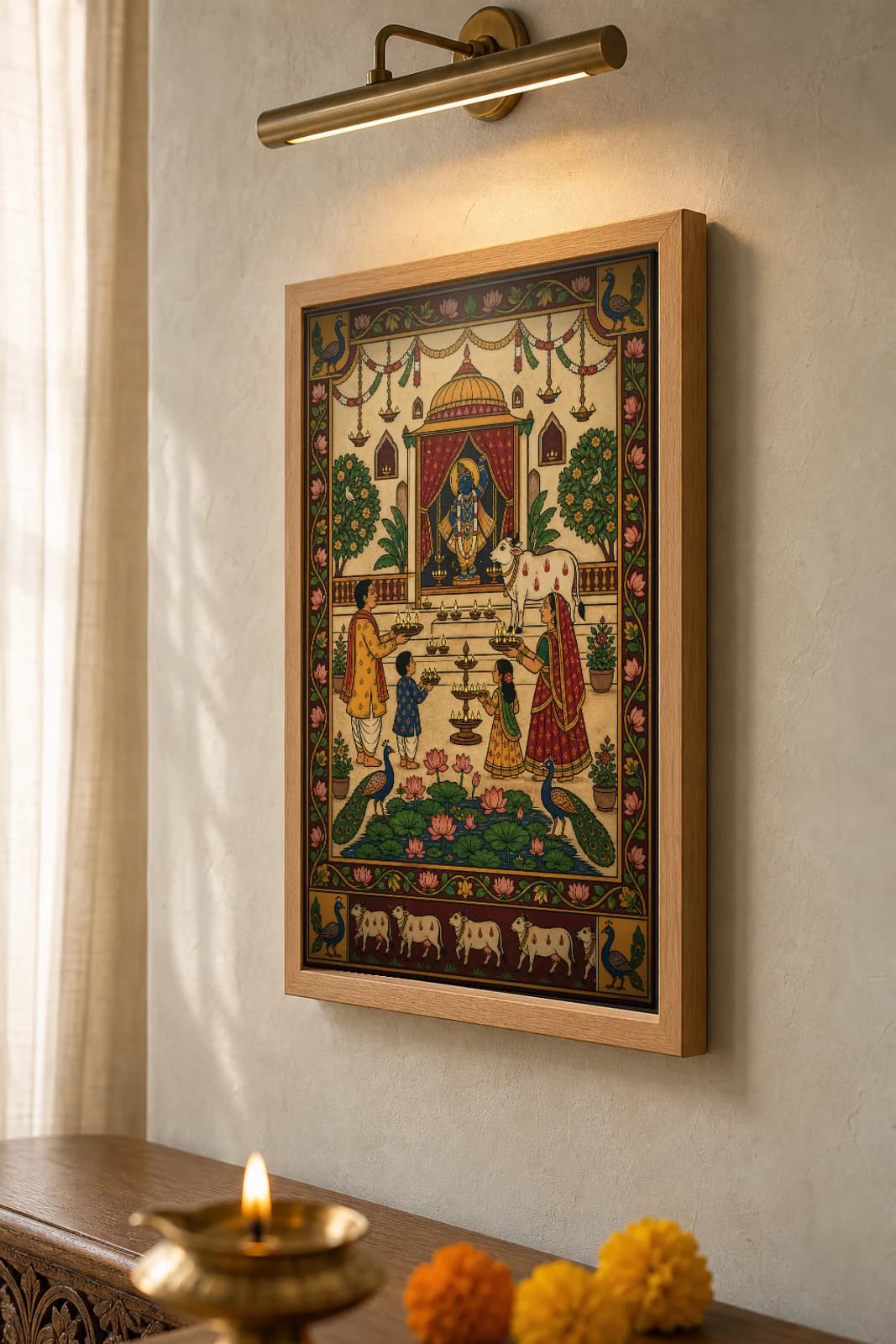 Sandhya Aarti Pichwai-Style Print — a family performing evening aarti to Shrinathji in a domed shrine with a white cow and rows of lamps, over a lotus pond, on warm cream cloth — the framed print shown at a three-quarter angle on a styled gallery wall in a natural-oak frame