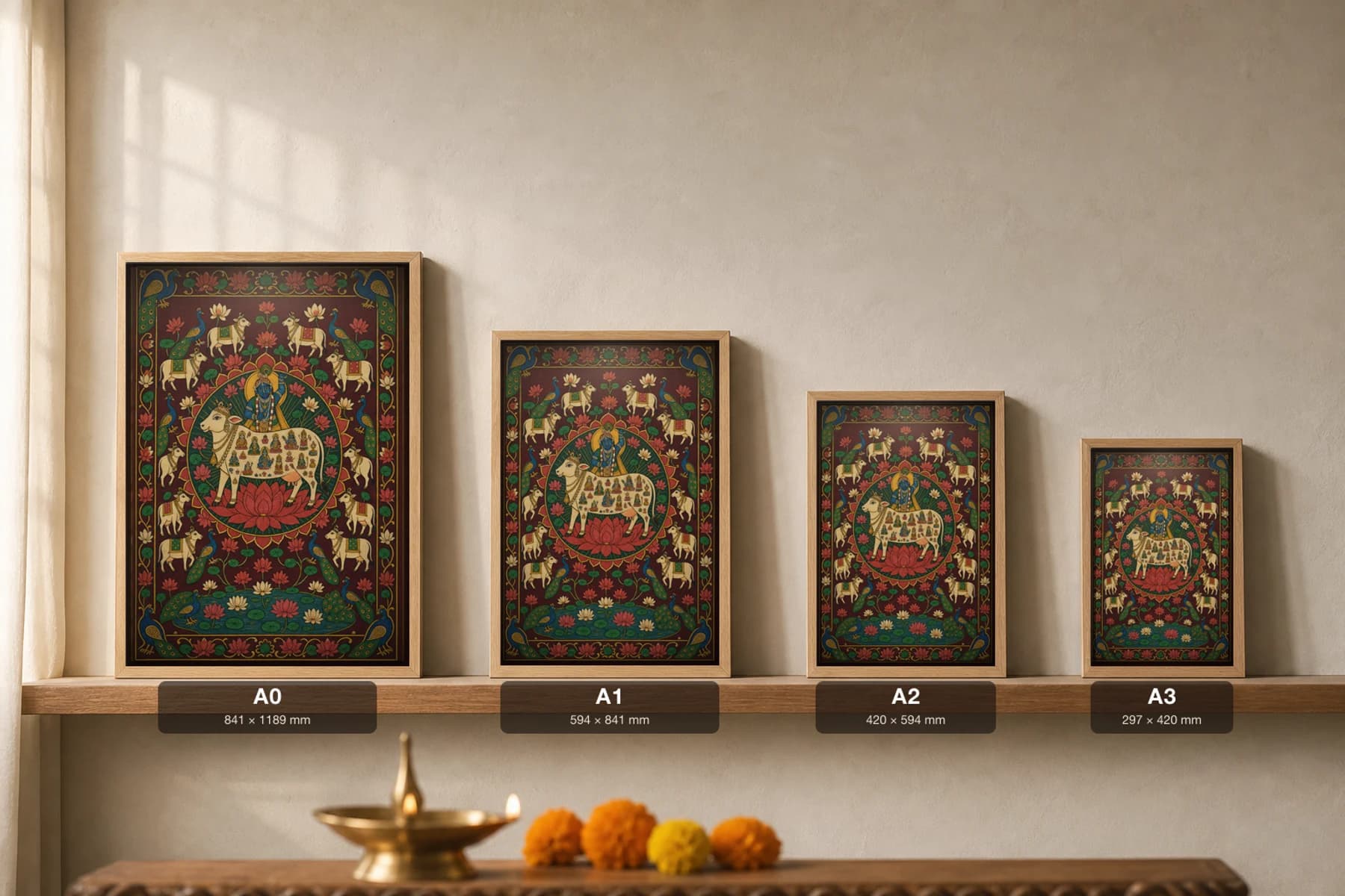 Kamadhenu Pichwai-Style Print — the sacred wish-cow holding many deities in her body with Krishna on her back, on a lotus medallion ringed by cows, on deep maroon cloth — print size guide showing the artwork at A0, A1, A2 and A3 in natural-oak frames at true relative scale