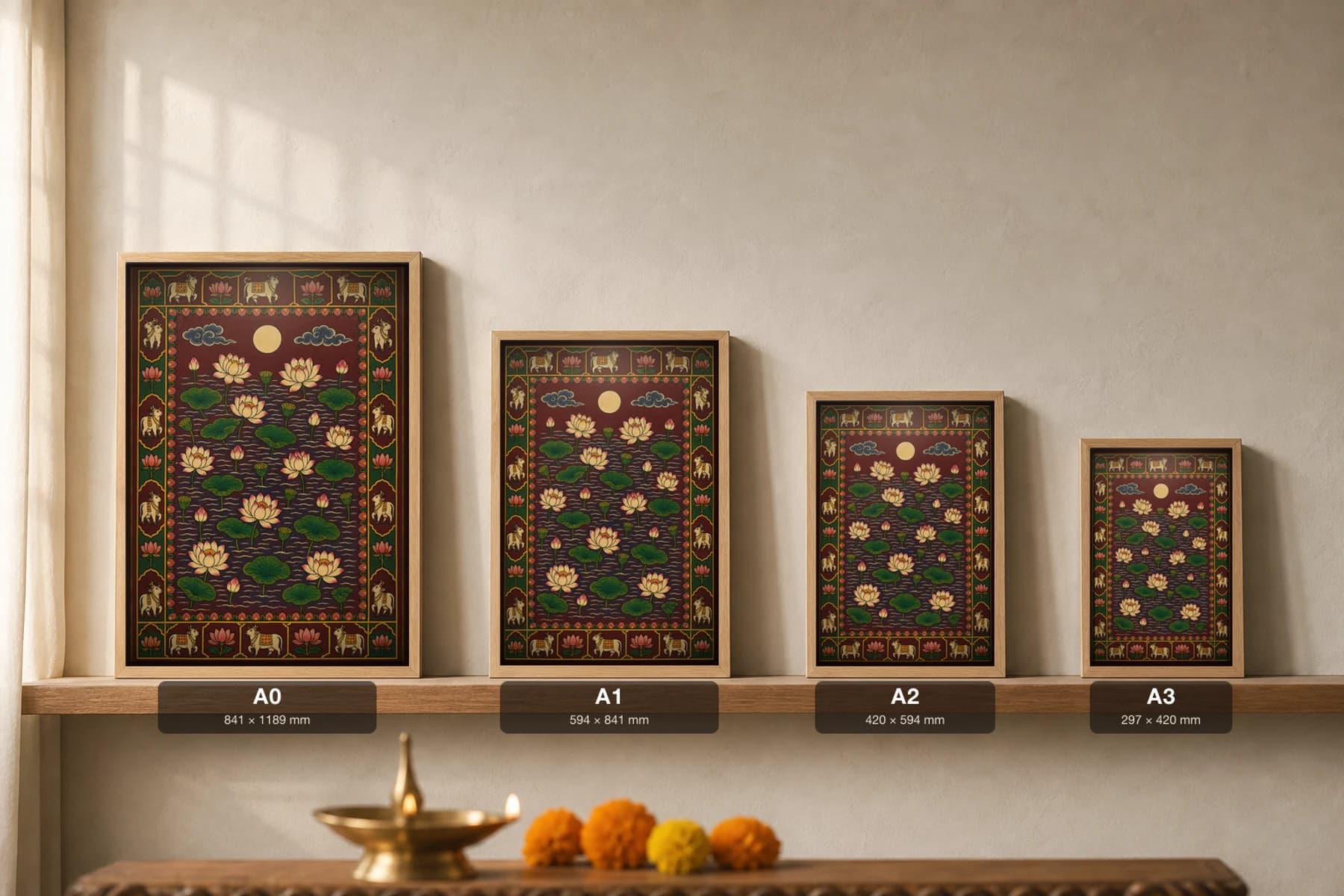 Rajni Kamal Pichwai-Style Print — a night lotus pond of pale blooms and green pads under a full moon on deep maroon water, with a cow-and-lotus border — print size guide showing the artwork at A0, A1, A2 and A3 in natural-oak frames at true relative scale