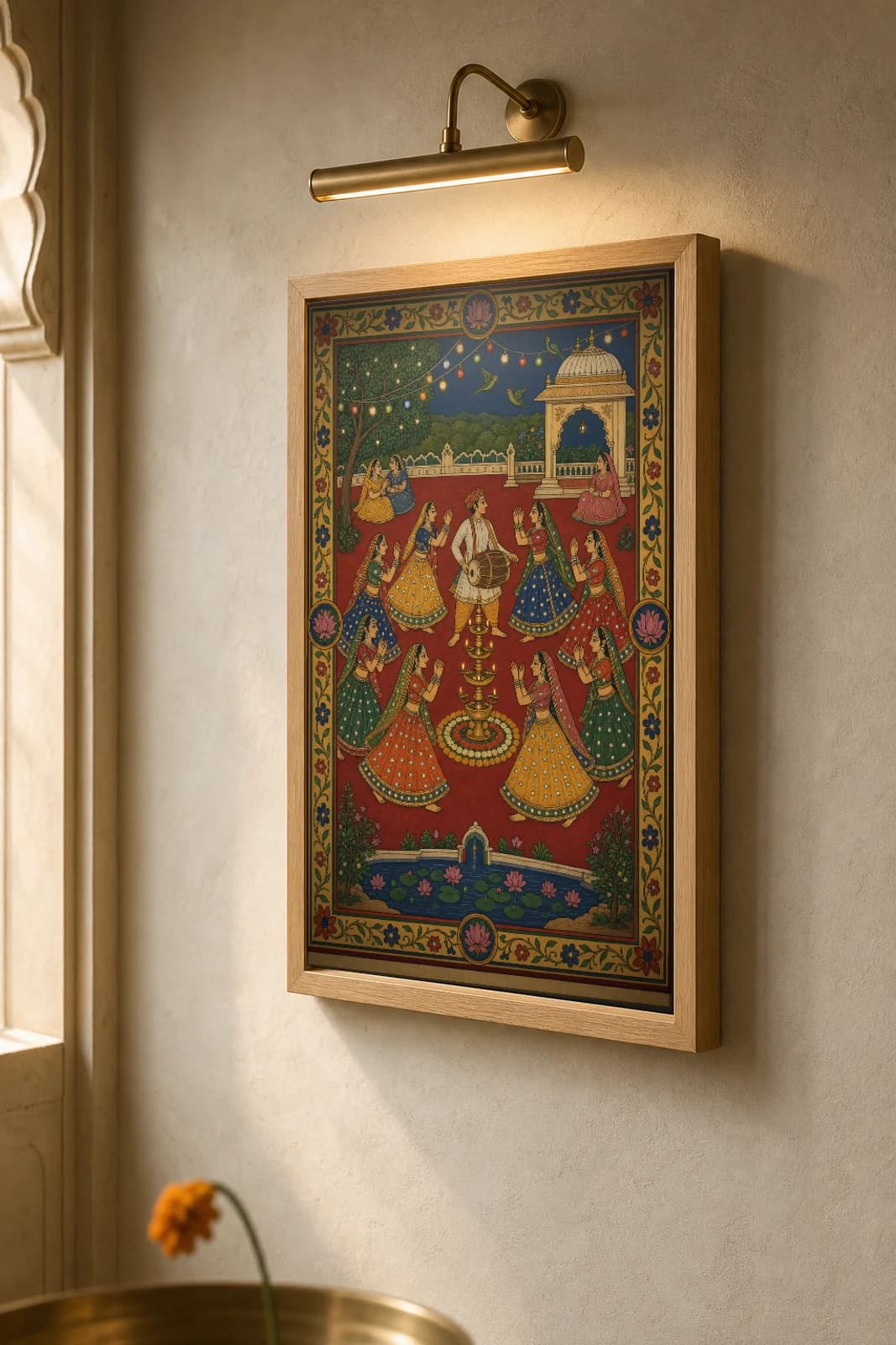 Garba Raas — Navratri Circle Dance Rajput Miniature Art Print · collector edition A2 · women circling a lamp-tower under string lights on a deep red ground, Mewar grammar — the framed print shown at a three-quarter angle on a styled gallery wall in a natural-oak frame