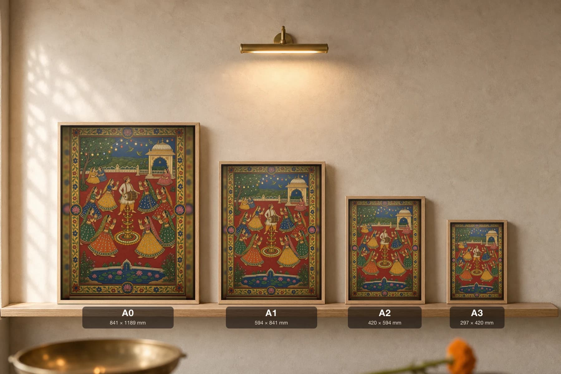 Garba Raas — Navratri Circle Dance Rajput Miniature Art Print · collector edition A2 · women circling a lamp-tower under string lights on a deep red ground, Mewar grammar — print size guide showing the artwork at A0, A1, A2 and A3 in natural-oak frames at true relative scale