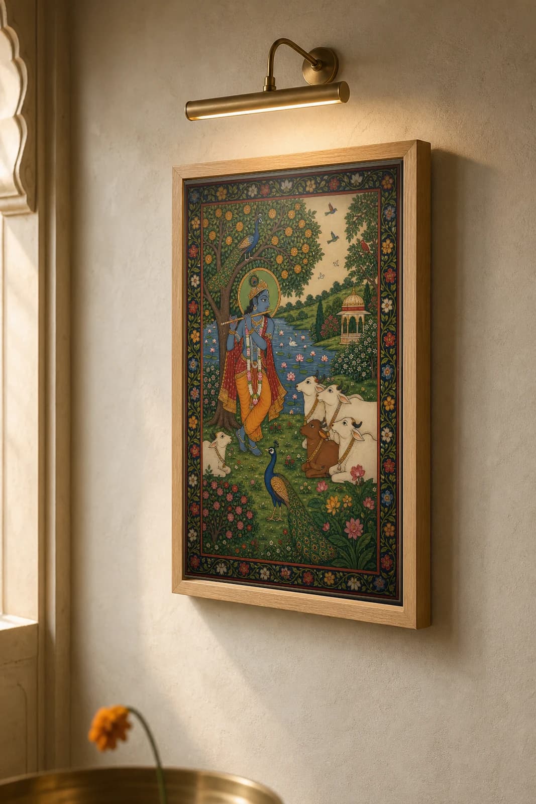 Krishna's Flute Rajput Miniature Print — Bundi Krishna-lila by the green Yamuna, cows and a peacock drawn to the flute · collector edition A2 — the framed print shown at a three-quarter angle on a styled gallery wall in a natural-oak frame