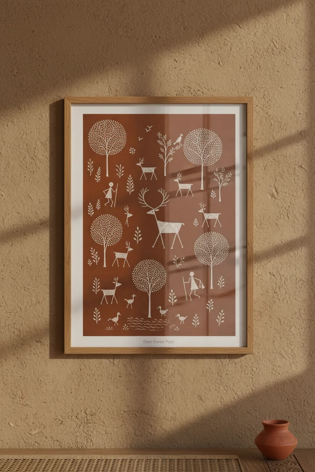 Deer Forest Path Warli print in natural oak A2 frame on warm-earth-neutral mud-plaster wall — rustic Indian folk art mockup