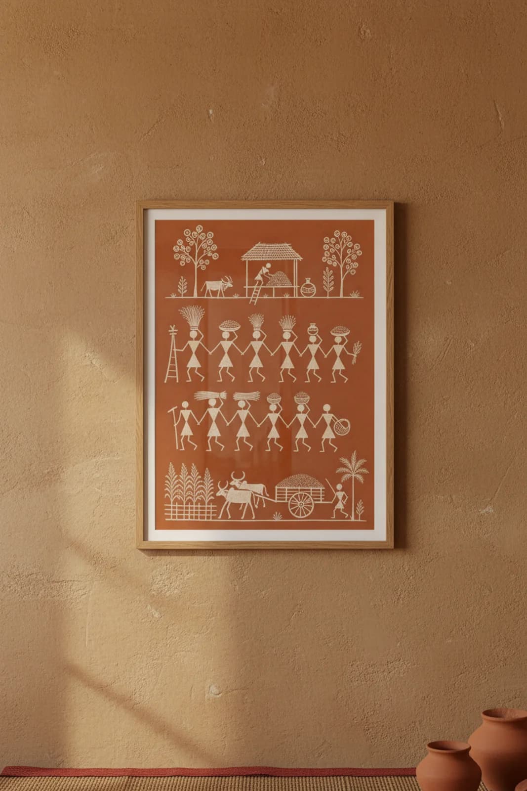 Harvest Gathering Warli print in natural oak A2 frame on warm-earth-neutral mud-plaster wall — rustic Indian folk art mockup