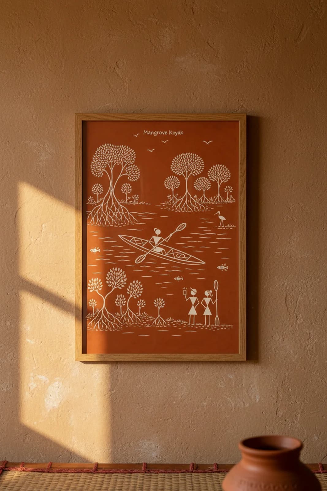 Mangrove Kayak Warli print in natural oak A2 frame on warm-earth-neutral mud-plaster wall — rustic Indian folk art mockup