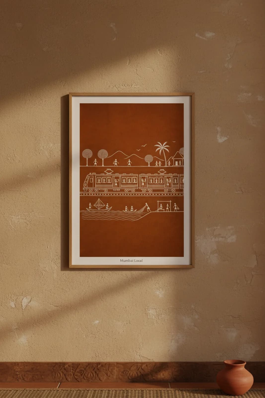 Mumbai Local Warli print in natural oak A2 frame on warm-earth-neutral mud-plaster wall — rustic Indian folk art mockup