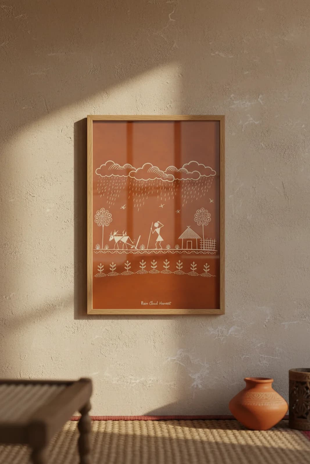 Rain Cloud Harvest Warli print in natural oak A2 frame on warm-earth-neutral mud-plaster wall — rustic Indian folk art mockup
