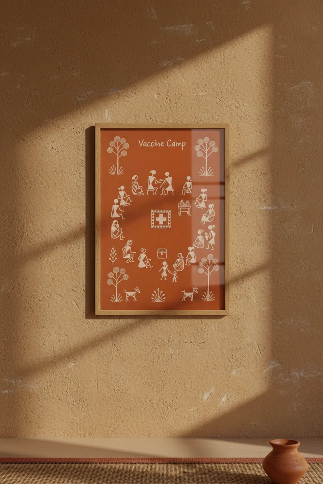 Vaccine Camp Warli print in natural oak A2 frame on warm-earth-neutral mud-plaster wall — rustic Indian folk art mockup